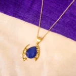 Stylish metal curb chain necklace with an organic-shaped pendant, enhanced with faceted blue teardrop stones, having a polished gold-tone finish, and a secure lobster claw clasp