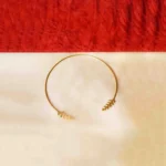 Sleek and sophisticated torque choker necklace in a brushed gold-tone finish, highlighted by hammered-textured leaf-shaped designs gracefully embellishing both ends