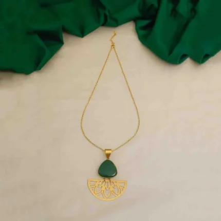 Modern yet vintage-inspired geometric flat cable chain necklace with a brushed gold-tone finish, featuring a bold triangular pendant set with a green stone, linked to a gracefully dangling semi-circular charm with delicate floral engravings, finished with a secure lobster claw clasp