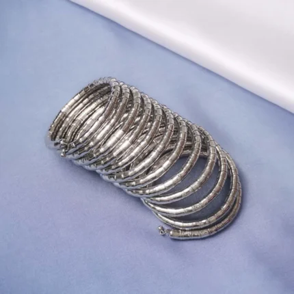 Contemporary metal spiral bracelet with a refined gold/silver texture, showcasing a multi-layered structure and bead details at both edges.