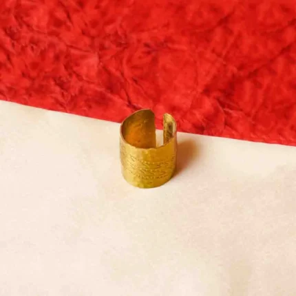 Elegant gold-tone ring featuring a cylindrical shape having a open-end design, and fine moulded texture with complex details