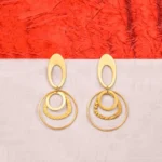Modern brass drop earring with a sculptural design, showcasing an oval-shaped top with a hollow center, two interlinked hoops, and a textured triangle charm gracefully dangling at the bottom, secured with a push-back closure