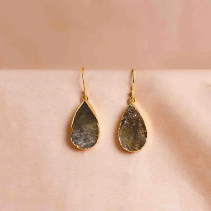 Long tiered Jhumka earring featuring an oxidized silver finish. It has three linked floral sections with dark pink enamel accents, leading down to a decorative bell-shaped drop with dangling beads.