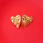 Trendy asymmetrical heart studs in a gold-tone finish, showcasing a distinctive wrinkle effect and a comfortable push-back fastening