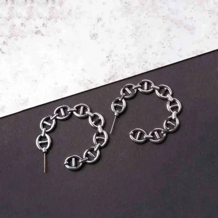 Trendy mini C-hoop earring with a polished silver-tone interlocking chain links and a small vintage-inspired coin charm, push-back post.
