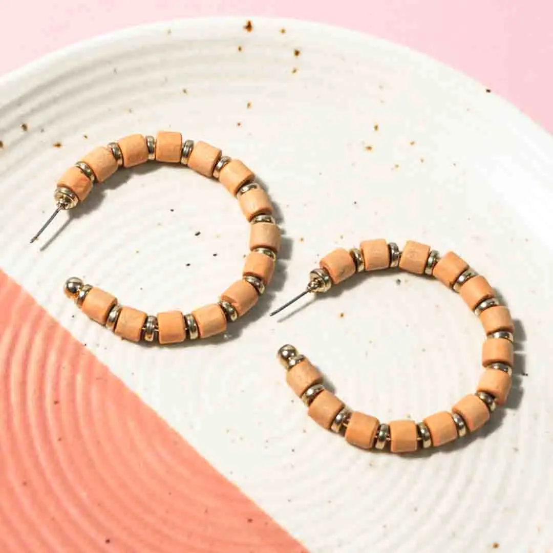 184-Th Chic metal hoop earrings featuring a polished gold-tone pearls, with peach coloured wooden beads along with small circular golden beads a push back for easy wear.
