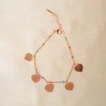 Sophisticated gold-tone curb chain bracelet with delicate multicolored flower-shaped charms, adding a fun and elegant touch, secured with a lobster clasp