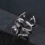 Sleek and contemporary dangle earrings with a coiled spiral structure, finished in a silver tone and secured with a push-back post.