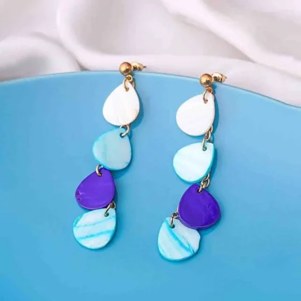 Sophisticated gold stud dangle earrings featuring a teardrop-shaped acrylic drop in a marbled blend of white and blue, secured with a push-back closure