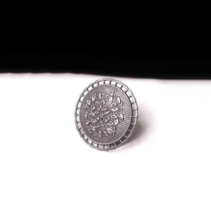 Artisan-crafted oxidized silver-tone statement ring with intricate floral embellishments and a prominent leafy design in the center