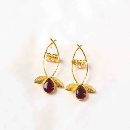 Charming oxidized silver-tone floral dangling earring with delicate detailing, red-colored teadrop shaped stones, two- textured leaves at the bottom, and a push-back post for a secure fit.