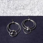 Sophisticated silver-toned hoop earring featuring a geometric double-hoop structure, a dainty dangling sphere, and a push-back fastening