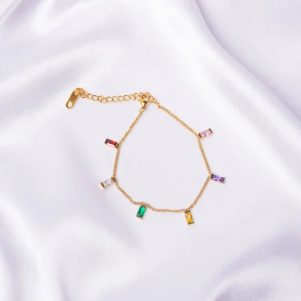 Dainty curb chain bracelet in a gold-tone finish, accented with tiny dangling rectangular gemstones in various colors and a lobster claw clasp