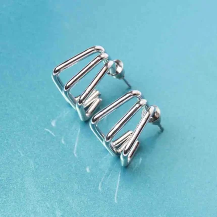 Chic metal hoop earrings featuring a polished silver-tone finish, playful geometric cage, and a push back for easy wear.