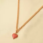 Elegant adjustable curb chain bracelet in a gold-tone finish, featuring a curved metallic wire centerpiece with a dangling spherical charm and a secure spring ring clasp.