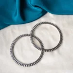 Antique-inspired oxidized silver-tone bangle set with finely detailed lines and circular metallic beaded designs.