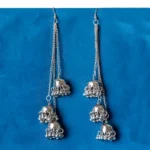 Statement oxidized silver tone tassel earrings featuring a delicately engraved long vrying jhumkas,ghungroos at the end, and finished with a push-back closure.