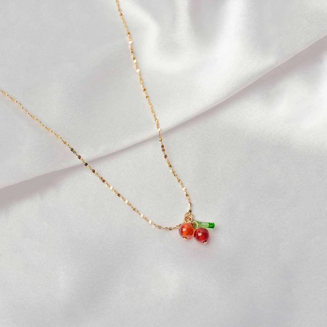 424-Th Playful and stylish gold-tone necklace with a textured chain, featuring a cute cherry pendant with two glossy cherries and a small green leaf, secured with a lobster claw closure