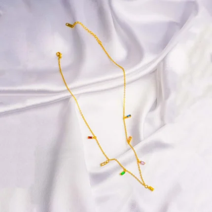 Stylish gold-tone necklace with a filled flat cable chain, an elegant teadrop shaped pendant,with delicate filigree and a green stone in the center and a lobster claw clasp.