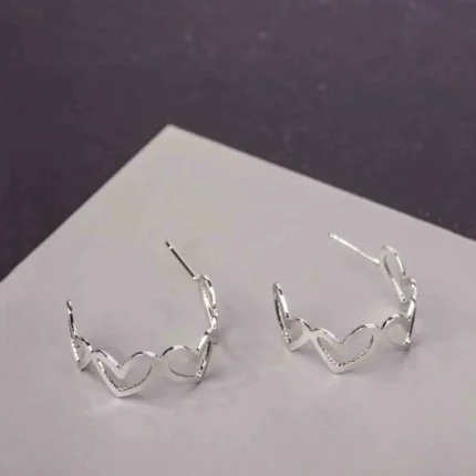 Trendy mini C-hoop earring with a polished silver-tone, heart shapded and , push-back post.