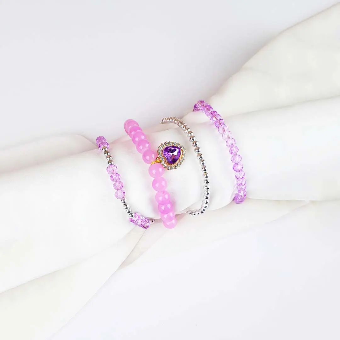 20251007_162212 (1) Pack of four beaded bracelets in lilac and silver tones. Each bracelet has a glossy or faceted finish and smooth elastic fit.