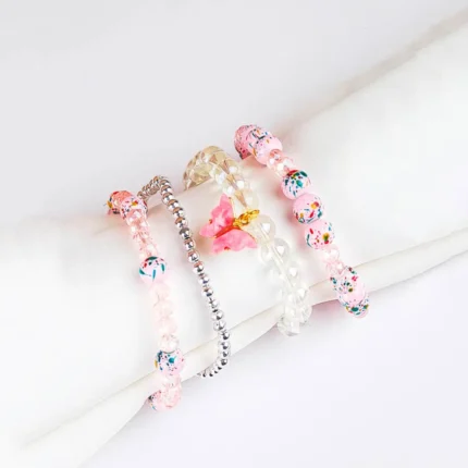 Pack of four pastel pink and clear glass beaded stretch bracelets, including a butterfly charm,