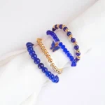 Pack of four royal blue beaded bracelets. One blue, one gold stretch beaded bracelets and two classic beaded bracelets, one with a butterfly charm.