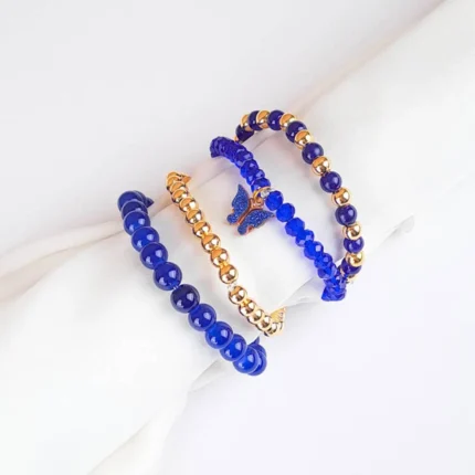 Pack of four royal blue beaded bracelets. One blue, one gold stretch beaded bracelets and two classic beaded bracelets, one with a butterfly charm.
