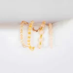 Pack of four neutral and gold beaded stretch bracelets, one with a moon charm.