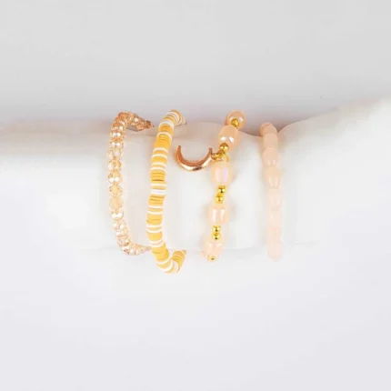 Pack of four neutral and gold beaded stretch bracelets, one with a moon charm.