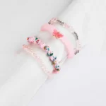 Pack of four pink beaded stretch bracelets, one with speckled beads and one with a butterfly charm