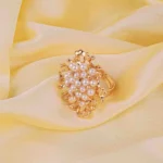 Elegant adjustable band ring with clustered pearls and intricate openwork design, exuding a refined statement style.