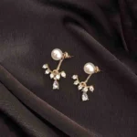 Gold-toned pearl stud earring with floral crystal design and teardrop stone