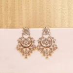 Gold-toned crescent chandelier earring with Kundan detailing, enamel accents, and hanging bead embellishments.
