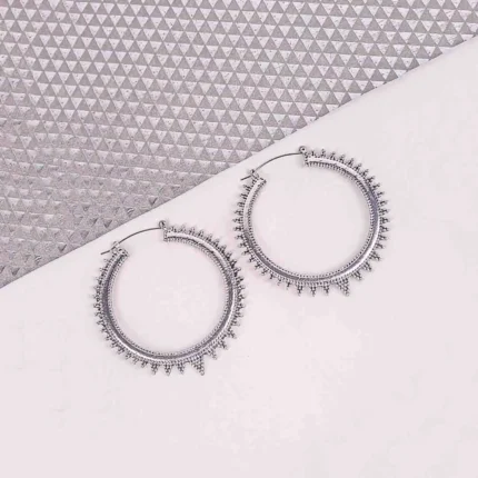 "Silver spiked hoop earrings with beaded edging, polished textured finish, and latch‑back closure. "