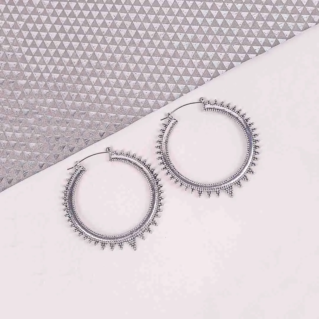 20251105_133927 "Silver spiked hoop earrings with beaded edging, polished textured finish, and latch‑back closure. "