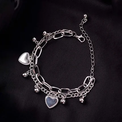Silver dual-layer bracelet with curb chain charms and gauge wire chain, secured with lobster claw clasp.