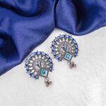 Oxidized silver half-moon stud earring with blue, brown, and green enamel detailing and a small hanging ghunghroo.