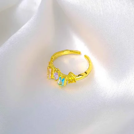 Gold adjustable open ring with pastel baguette crystals.