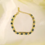 Dual chain bracelet with gold-toned beads, polished bar, and linked dark oval beads for layered chic style.