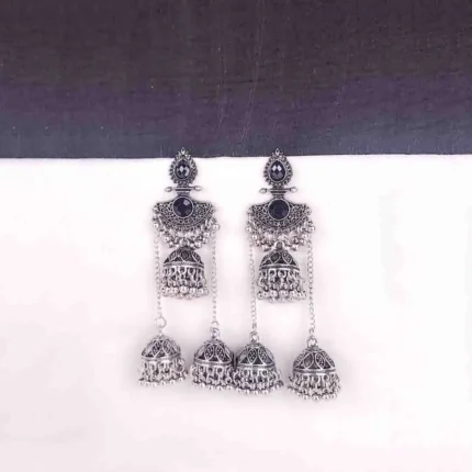 Traditional oxidized jhumka earrings featuring black stone studs and layered triple jhumkis.