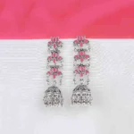 Long tiered Jhumka earring featuring an oxidized silver finish. It has three linked floral sections with dark pink enamel accents, leading down to a decorative bell-shaped drop with dangling beads.