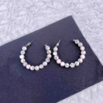 Hoop earrings with white marble beads and gray veining, polished finish, and latch-back closure.