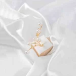 Multi-band adjustable ring with delicate pearl accents on slender metallic branches, polished to a refined finish.