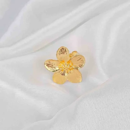 Gold-tone statement ring with textured flower design and adjustable band.