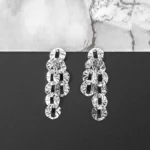 Silver drop earrings with sculpted textured discs and push-back closure, featuring a contemporary geometric design.