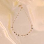  Gold chain necklace with polished disc charms and adjustable lobster clasp.