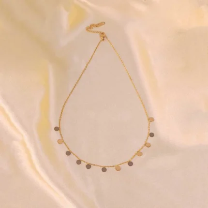  Gold chain necklace with polished disc charms and adjustable lobster clasp.