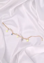  Layered gold bracelet with star charms, turquoise bead, paperclip chain, and lobster clasp.
