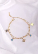  Layered gold bracelet with star charms, turquoise bead, paperclip chain, and lobster clasp.